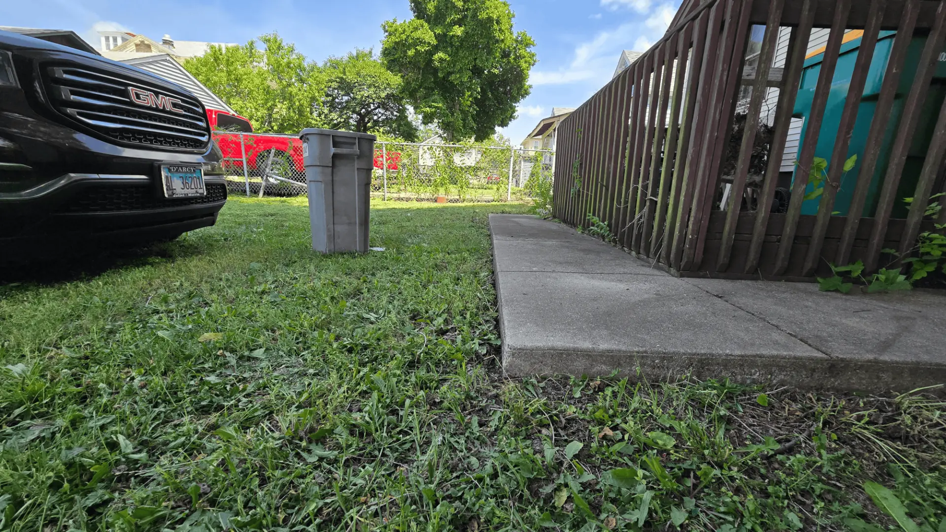 Freshly mowed side yard along a trimmed sidewalk and fence line